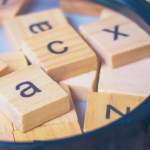 Tiles with letters on them and a magnifying glass