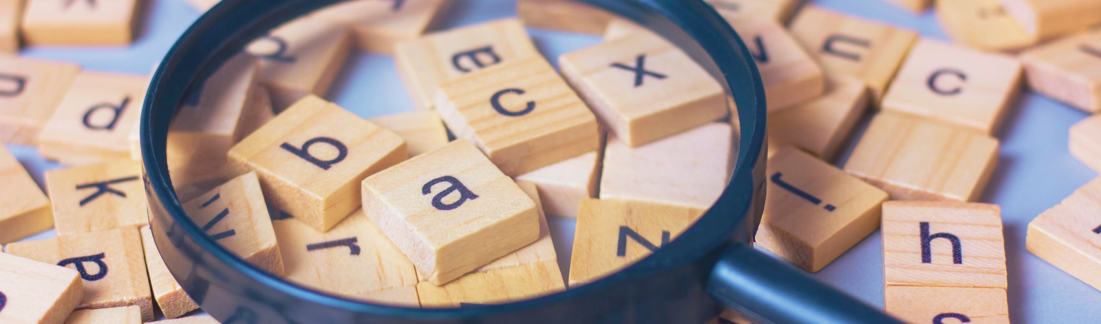 Tiles with letters on them and a magnifying glass